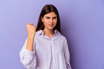 Fototapeta premium Young caucasian woman isolated on purple background showing fist to camera, aggressive facial expression.