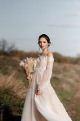 Fototapeta na wymiar A beautiful bride in a light dress poses. Boho style.