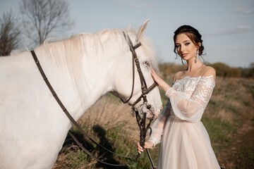 A beautiful bride in a light dress poses. Boho style.