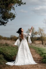 A beautiful bride in a light dress poses. Boho style. 