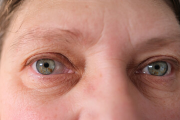 close up gray eye with spots on the iris, elderly woman opening blinking macro beauty, fine...