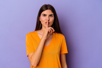Young caucasian woman isolated on purple background keeping a secret or asking for silence.