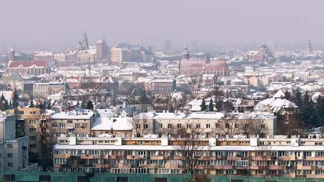 Panoramic footage of Wawel Royal Castle from Krakus Mound, the highest point in the city of Krakow, Poland. City skyline. Ancient buildings against the clear white sky in the background. 
