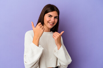 Young caucasian woman isolated on purple background raising both thumbs up, smiling and confident.