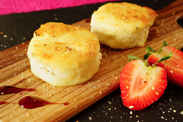 Cheesecakes with strawberries. Two fried curds on a black tray. Close-up - 431810477