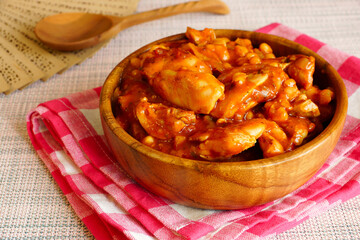Chicken with beans in a wooden bowl. Chicken fillet with beans, stewed in tomato sauce in a wooden bowl - 431810485