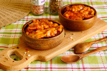 Chicken fillet with beans. Two wooden bowls with chicken stewed in tomato sauce. Serving the dish - 431810487