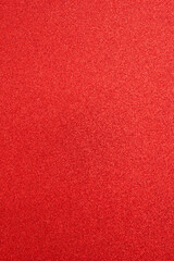 Textured surface red paper with sparkles, defocused. Abstract holiday shiny background, design element