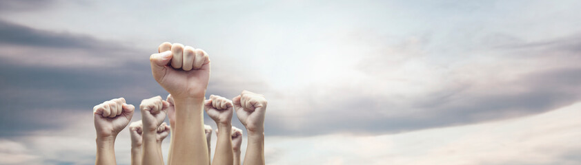 Man hands with clenched fist on sky background expressing freedom