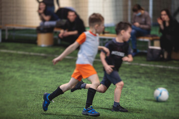 Obraz premium Football soccer game for kids, junior young football team group of children team having training session, or football game on a pitch, running and kicking ball on green pitch