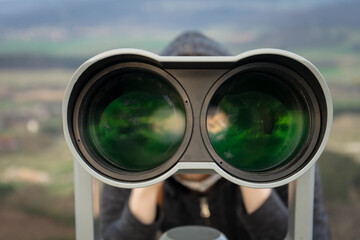 young man watching with a binocular,
tactical spying outdoors