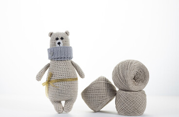Toy bear with skeins of yarn on white isolated background with copy space