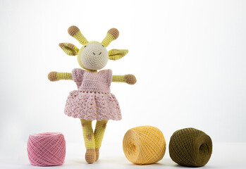 Knitted deer with balls of multi-colored threads on an isolated background. Amigurumi