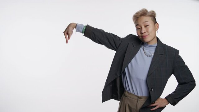 Non-binary Asian professional interacting with white graphic space