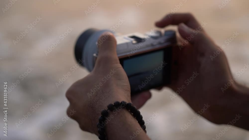 Poster person hands clicking camera button to capture scenic view of splashing waves. - selective focus sho