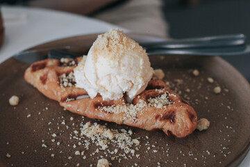 Fresh homemade waffles with ice cream and maple syrup. Delicious sweet dessert. Summer, open space