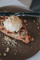 Fresh homemade waffles with ice cream and maple syrup. Delicious sweet dessert. Summer, open space