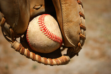 Person catching baseball with leather glove