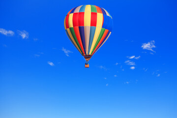 Fototapeta na wymiar Hot air balloon in flight on the clear sky . Multi Colored air balloon . Traveling by air