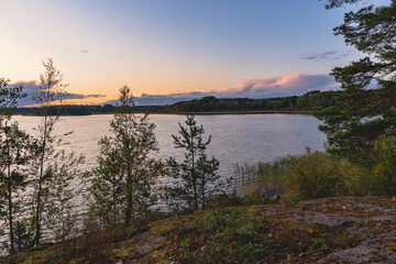 Naklejka na ściany i meble Sunset on a lake with rocky shores in Karelia