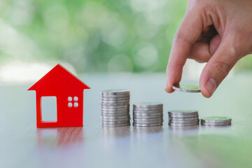 Hand putting money coin stack, House model and coin, business investment for real estate, Property...