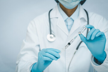 Female doctor holds syringe and bottle with vaccine for coronavirus cure.s, Concept fight against virus covid-19 corona virus. COVID-19 vaccine in researcher hands.