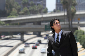 Young Japanese businessman walking in the american business district	
