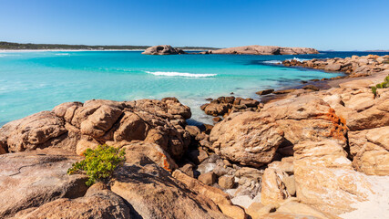 Landscape view of the prisitne white sands, crystal clear aqua water and granite boulders on a clear blue day at Twilight Cove, near Esperance in Western Australia.