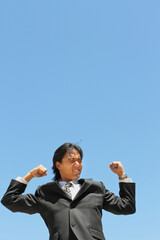 A young Japanese businessman stretching in a business district in Los Angeles, USA