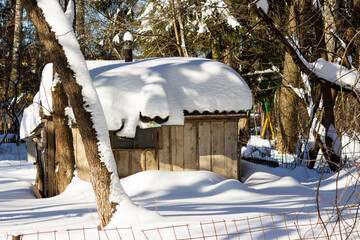 The roof of a wooden shed covered with snow after a long snowfall