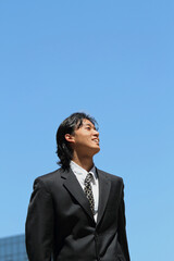 Young Japanese businessman walking in the american business district	
