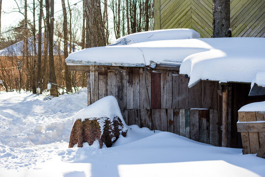 The roof of a wooden shed covered with snow after a long snowfall