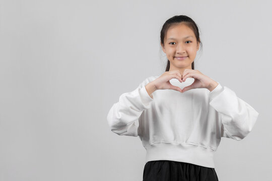 Cute Little Girl Showing Love Sign, On Gray Background, Better Eyesight Vision Concept. Head Shot Close-up Little Cutie Making Heart Gesture.
