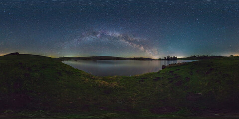 Spherical night panorama overlooking the lake under a bright starry sky. Beautiful arch of the Milky Way. 360 degree spherical panorama.