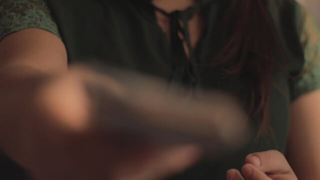 Close up of woman's hands with short nails, paying with Mexican five hundred peso bills.