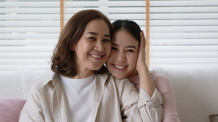 Close up attractive beautiful two asia people face cheek smile to camera authentic real family mum and adult kid in woman power day, diverse ethnic people, genes genetics ginger mom skincare concept.