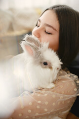 Girl playing with a white rabbit