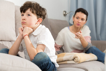 Worried mother scolding upset preteen son at home. Family conflicts concept..