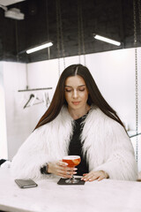 Girl drinking a red cocktail in a cafe