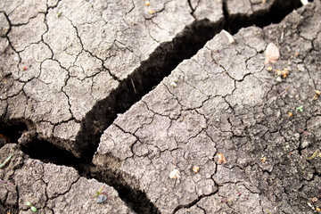 Deep cracks in the ground. The dry ground cracked.
