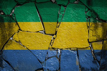 National flag of Gabon. depicting in paint colors on an old stone wall. Flag  banner on broken  wall background.