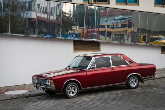 Alanya, Turkey  &ndash; April 17  2021:  red Ford P7   is driving fast on the street on a warm summer day against the backdrop of a  palms