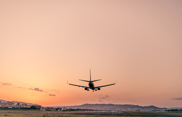 夕焼けを背景に着陸する飛行機