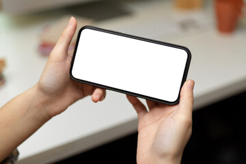 Close up view of female hands holding smartphone and showing horizontal mock-up screen