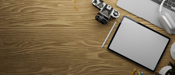 3D rendering, digital tablet with mock-up screen on wooden table with camera, laptop, accessories and copy space