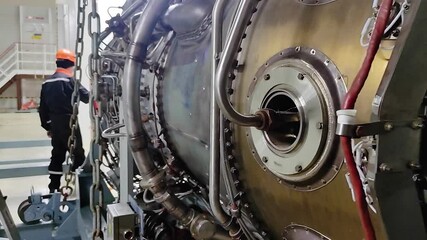 The mechanic is servicing the aircraft engine. Jet engine nozzle. Fuel line. Jet engine repair. Maintenance of the turbojet engine. Close-up. - Powered by Adobe