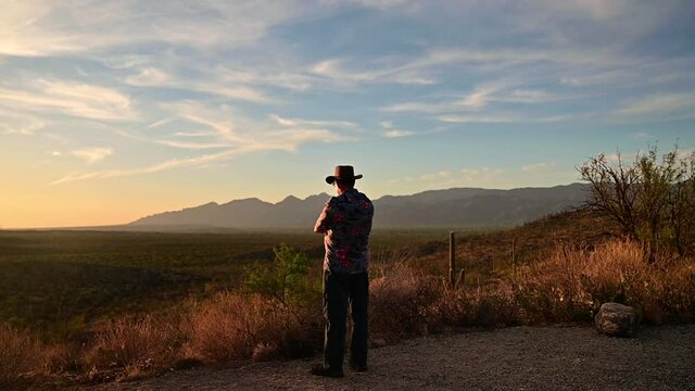 Man admires sunset at Saguaro National Park, Tucson, Arizona. Gimbal, slow pan left