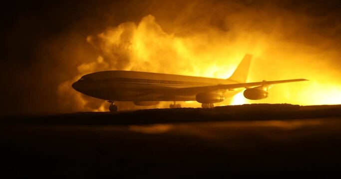 Air Crash. Burning falling plane. The plane crashed to the ground. Decorated with toy at dark fire background. Air accident concept. Selective focus