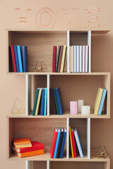 Shelf unit with books and decor near color wall