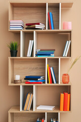 Shelf unit with books and decor near color wall